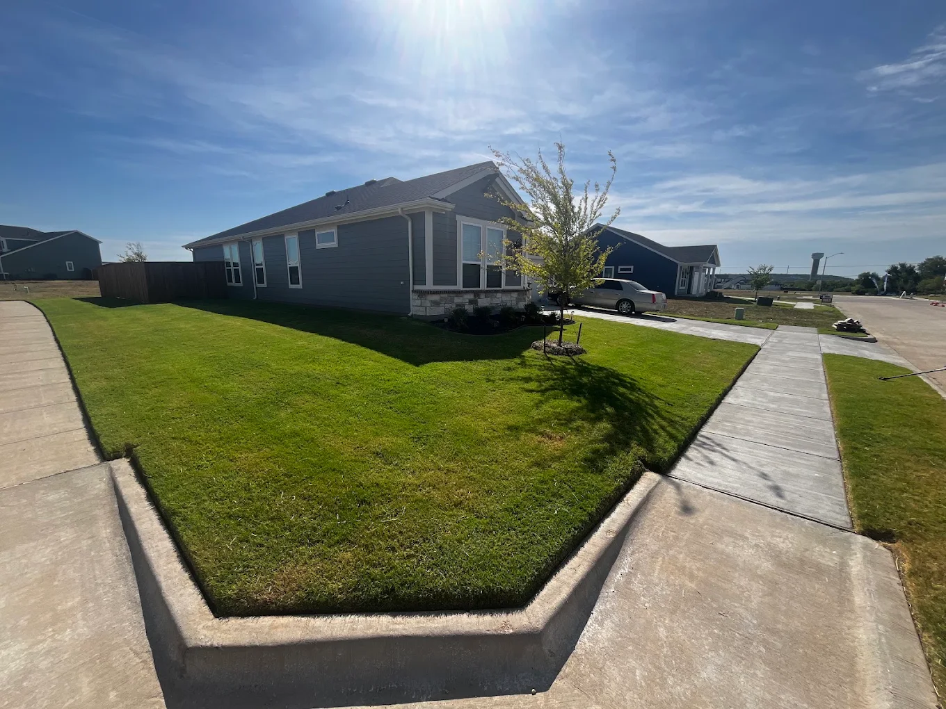 Lawn care professional mowing a green suburban lawn